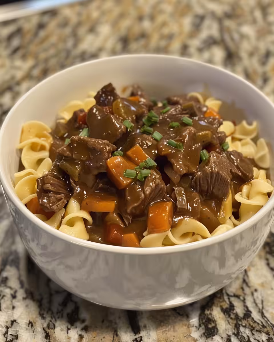 Crockpot beef and noodles in slow cooker with steam rising